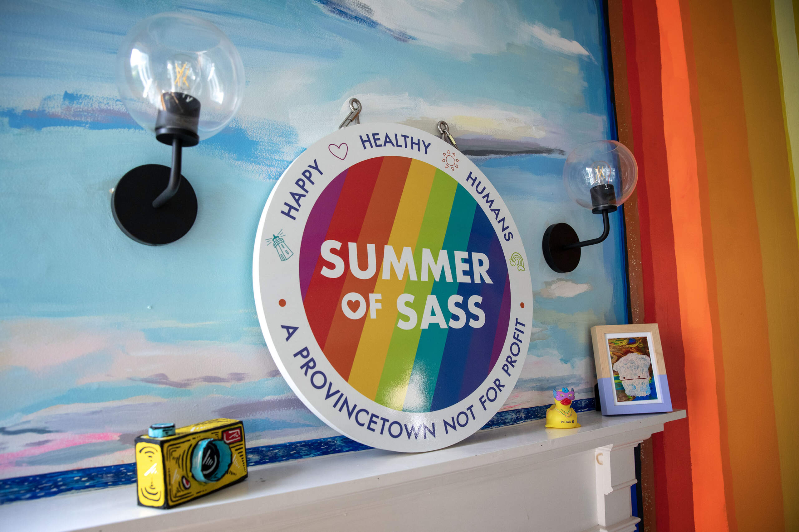 A sign that reads "happy, healthy humans" at the Summer of Sass house in Provincetown. (Robin Lubbock/WBUR)