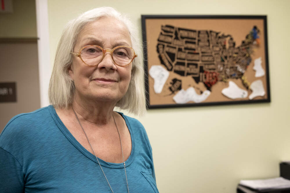 Dr. Lolly Delli-Bovi stands in front of a map her staff began using after the Dobbs decision to show the home states of patients traveling to Brookline for an abortion. (Robin Lubbock/WBUR)