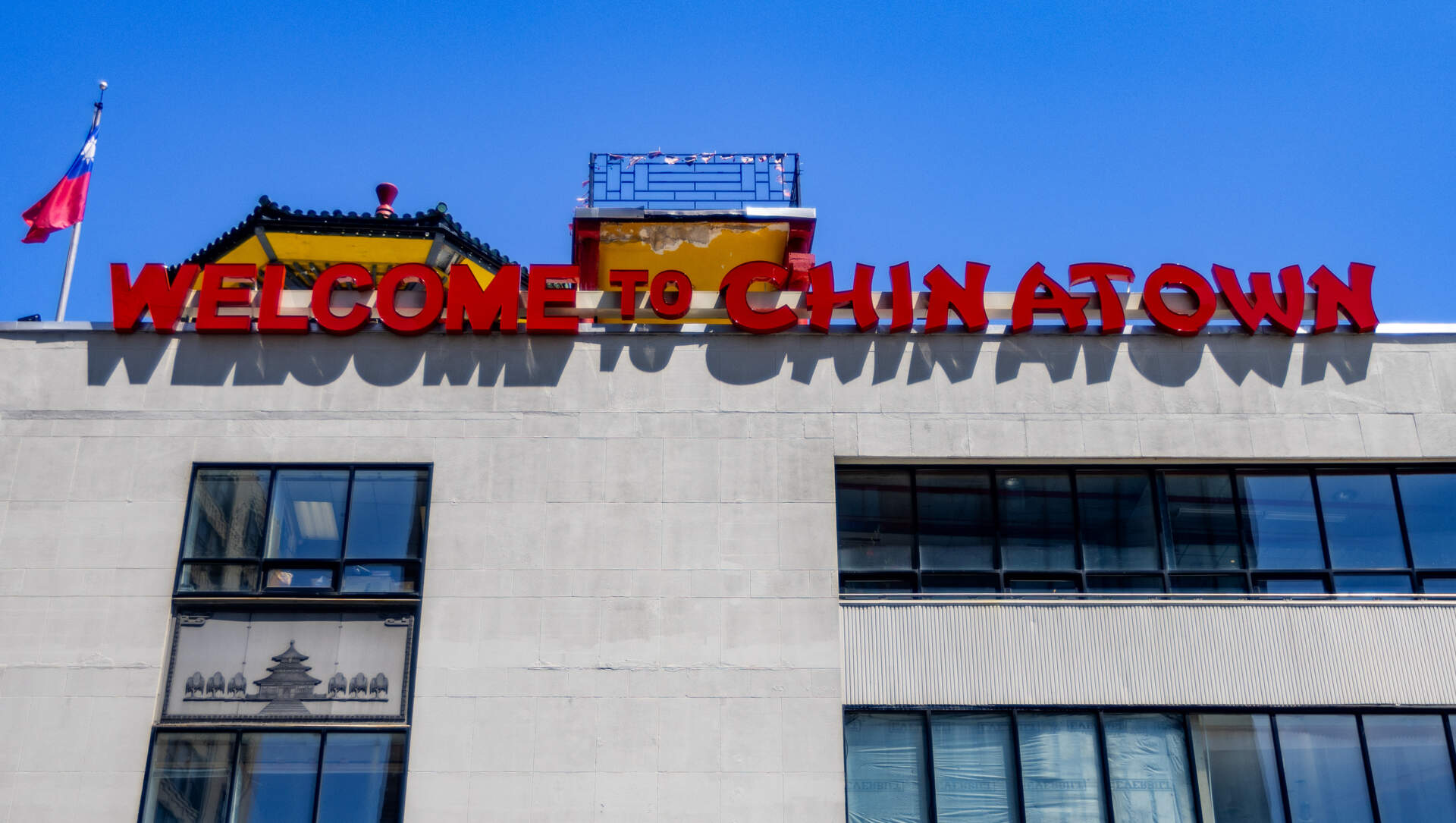 The sign welcoming people to Chinatown sits atop the building at 20 Hudson St. (Jesse Costa/WBUR)