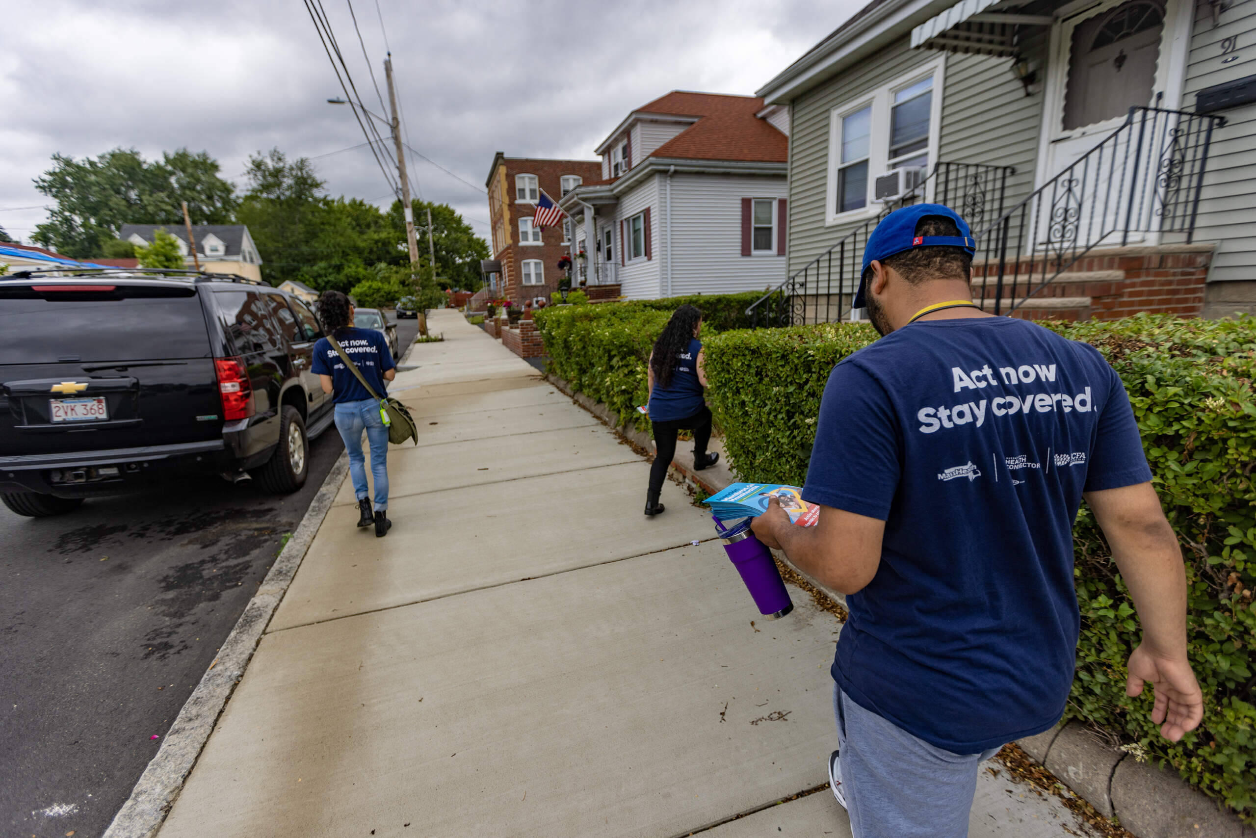 Danielle O’Brien, Carrie Perez, and Darius Barnett go door to door in Revere to hand out information about MassHealth renewals. (Jesse Costa/WBUR)