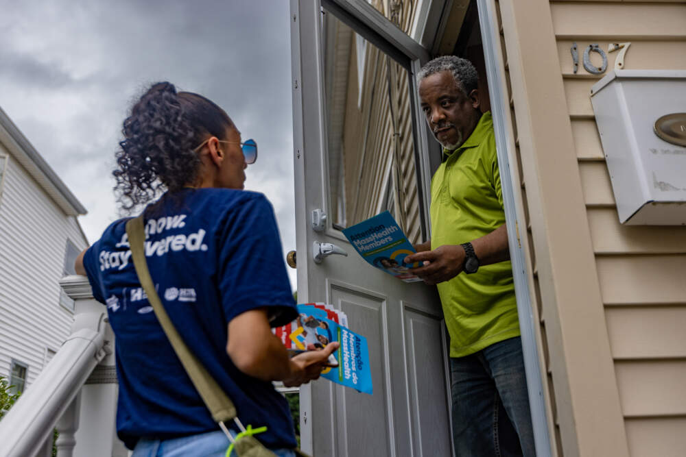 An outreach worker in Revere shares information about MassHealth. (Jesse Costa/WBUR)