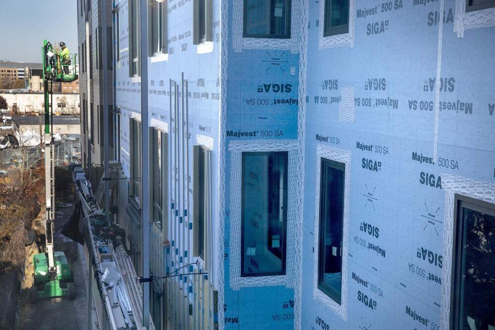 Blue air barrier wrap and air barrier sealing tape around the windows aims to maintain the airtight envelope wrapped around the passive house. (Robin Lubbock/WBUR)