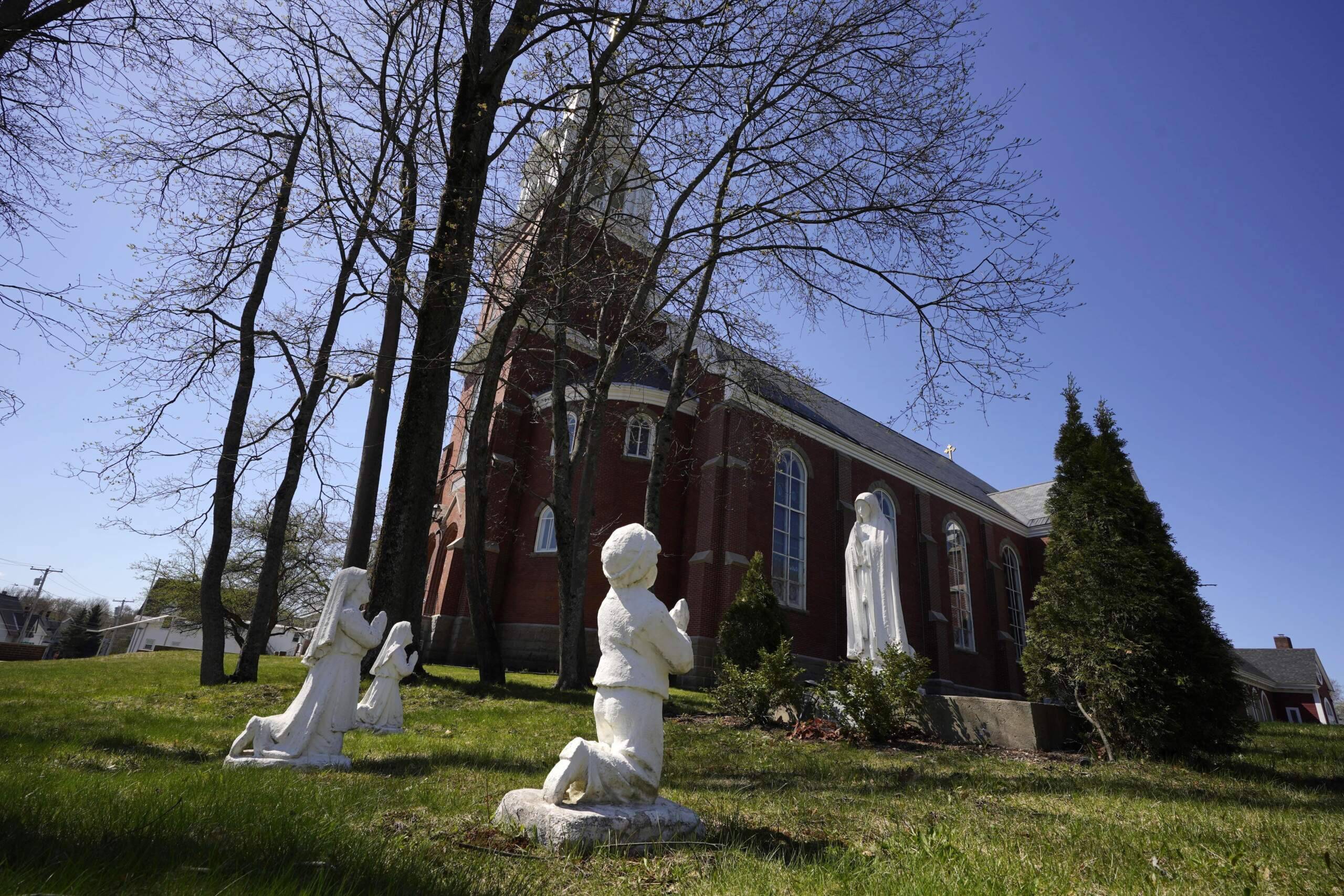 Statues of nuns and a boy praying stand outside Holy Family Catholic Church, Friday, April 28, 2023, in Old Town, Maine. Robert Dupuis, of East Lyme, Conn., says he was abused as a boy at the church when it was known as St. Joseph Catholic Church. (Robert F. Bukaty/AP)