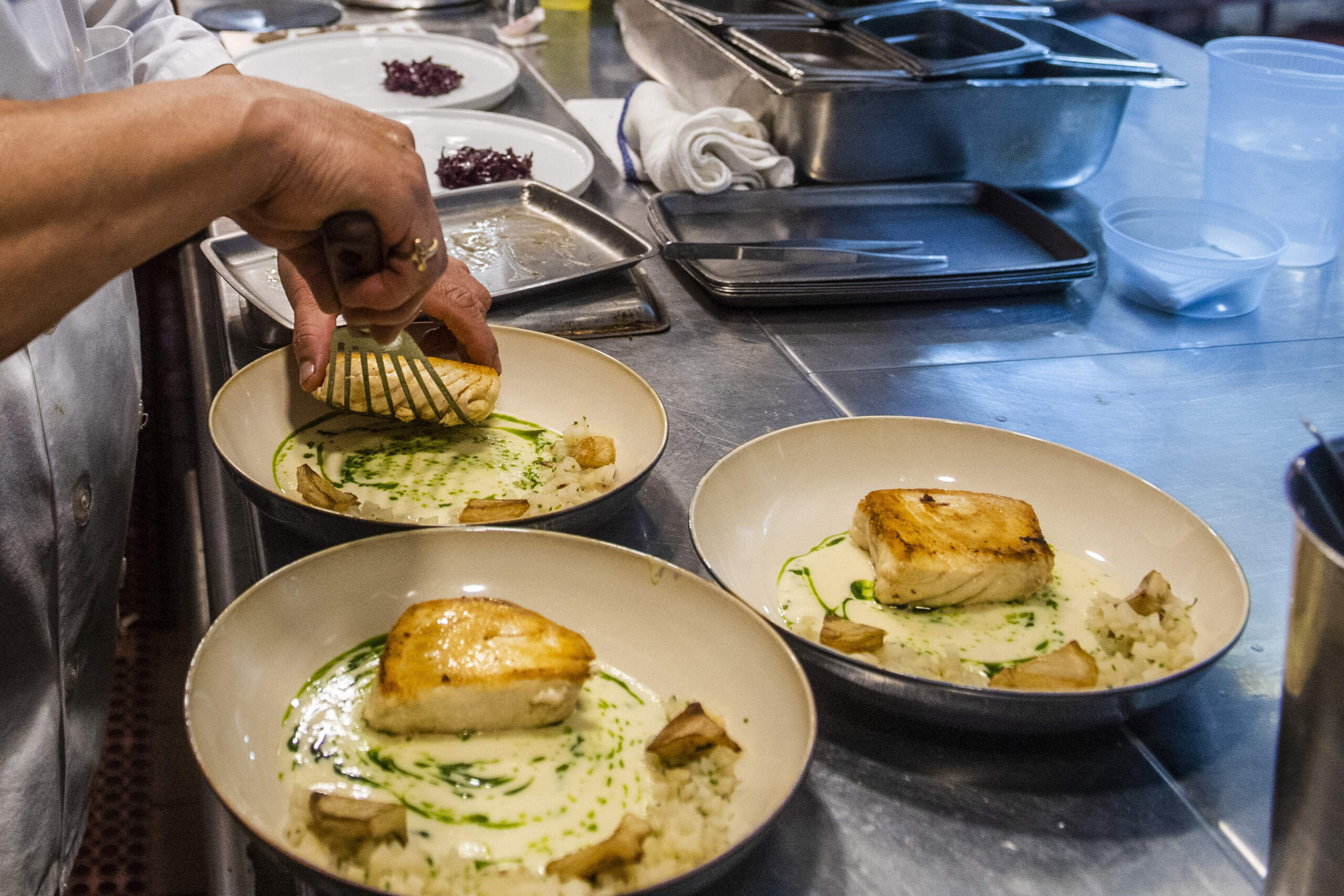 A worker arranges food onto plates in the kitchen of a restaurant in New York. (Brittainy Newman/AP)
