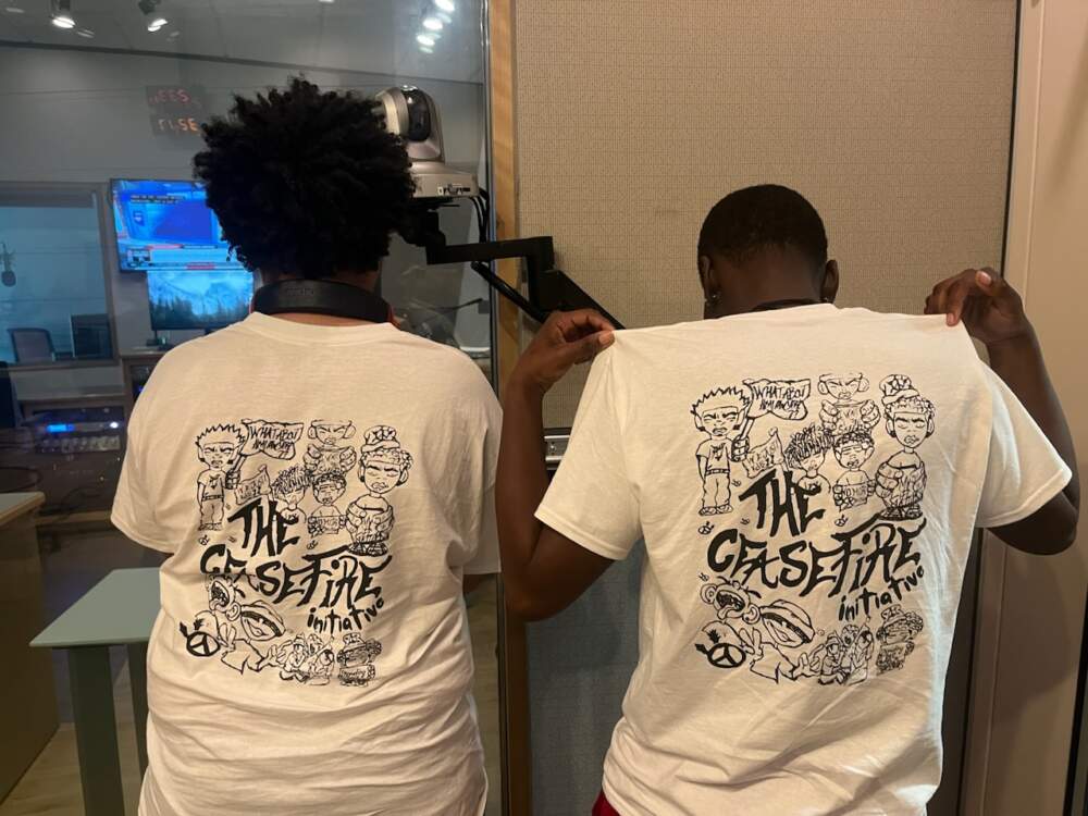 Maceo Right and Miko Clarke show off their T-shirts, which Clarke designed, for the Ceasefire Initiative against gun violence, which included the die-in. (Laney Ruckstuhl/WBUR)