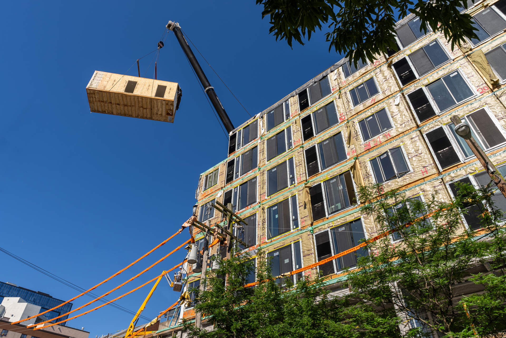 A crane lifts up a single factory-made apartment module for a building in Philadelphia. (Courtesy VBC)