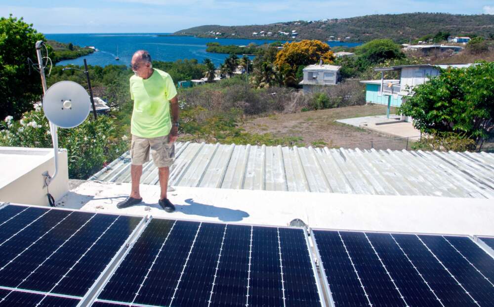 Nelson Meléndez with his rooftop solar panels in Culebra. (Chris Bentley/Here & Now)