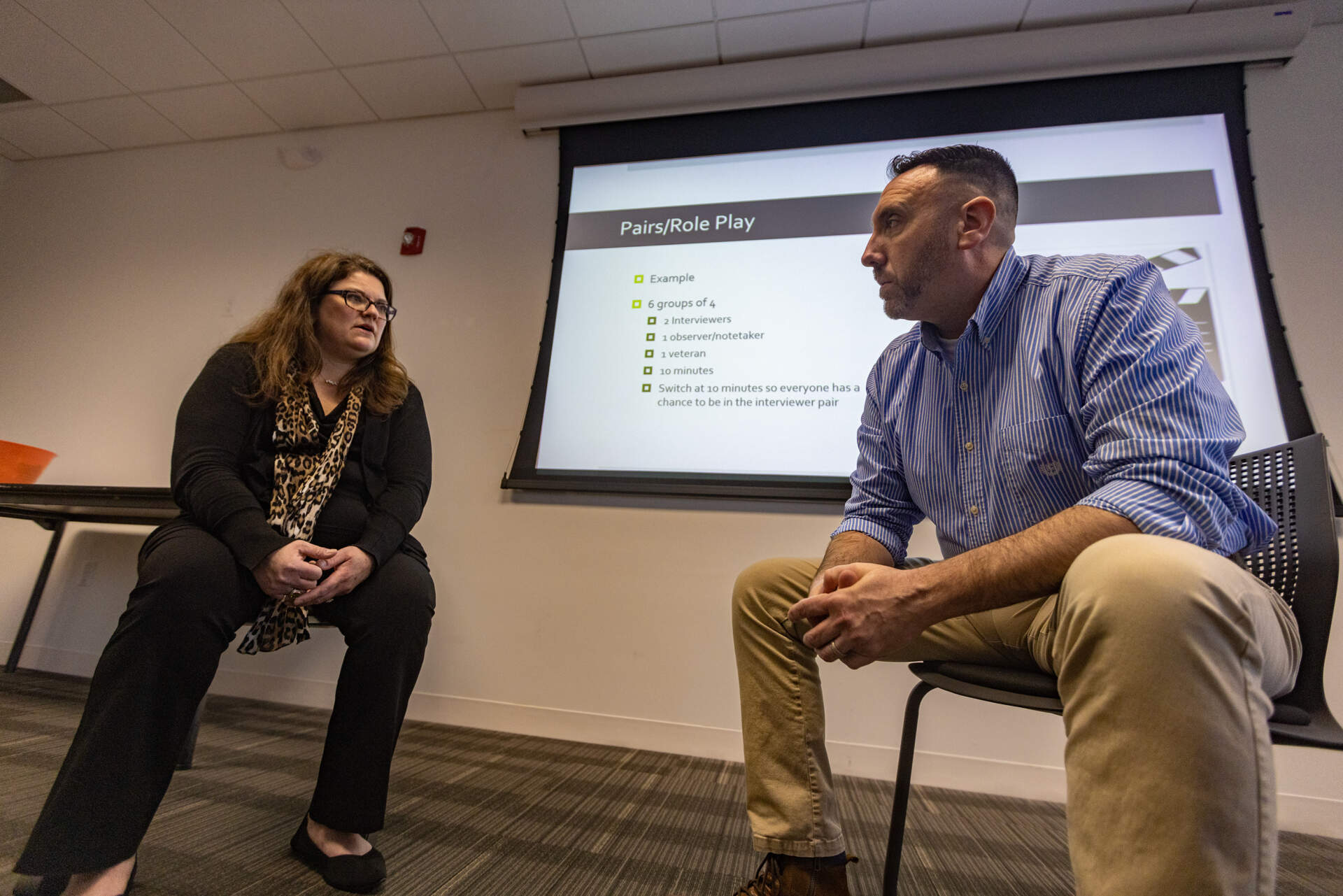 Jenny D’Olympia and Framingham police sergeant and Army veteran Jay Ball, also an instructor in the program, role-play as a therapist and veteran talking about safer gun storage. (Jesse Costa/WBUR)