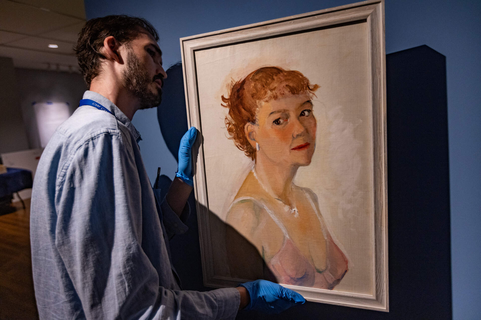 Leon Doucette hangs Josephine Hopper’s self-portrait on the wall as part of the exhibit “Edward Hopper &amp; Cape Ann: Illuminating an American Landscape” at the Cape Ann Museum in Gloucester. (Jesse Costa/WBUR)