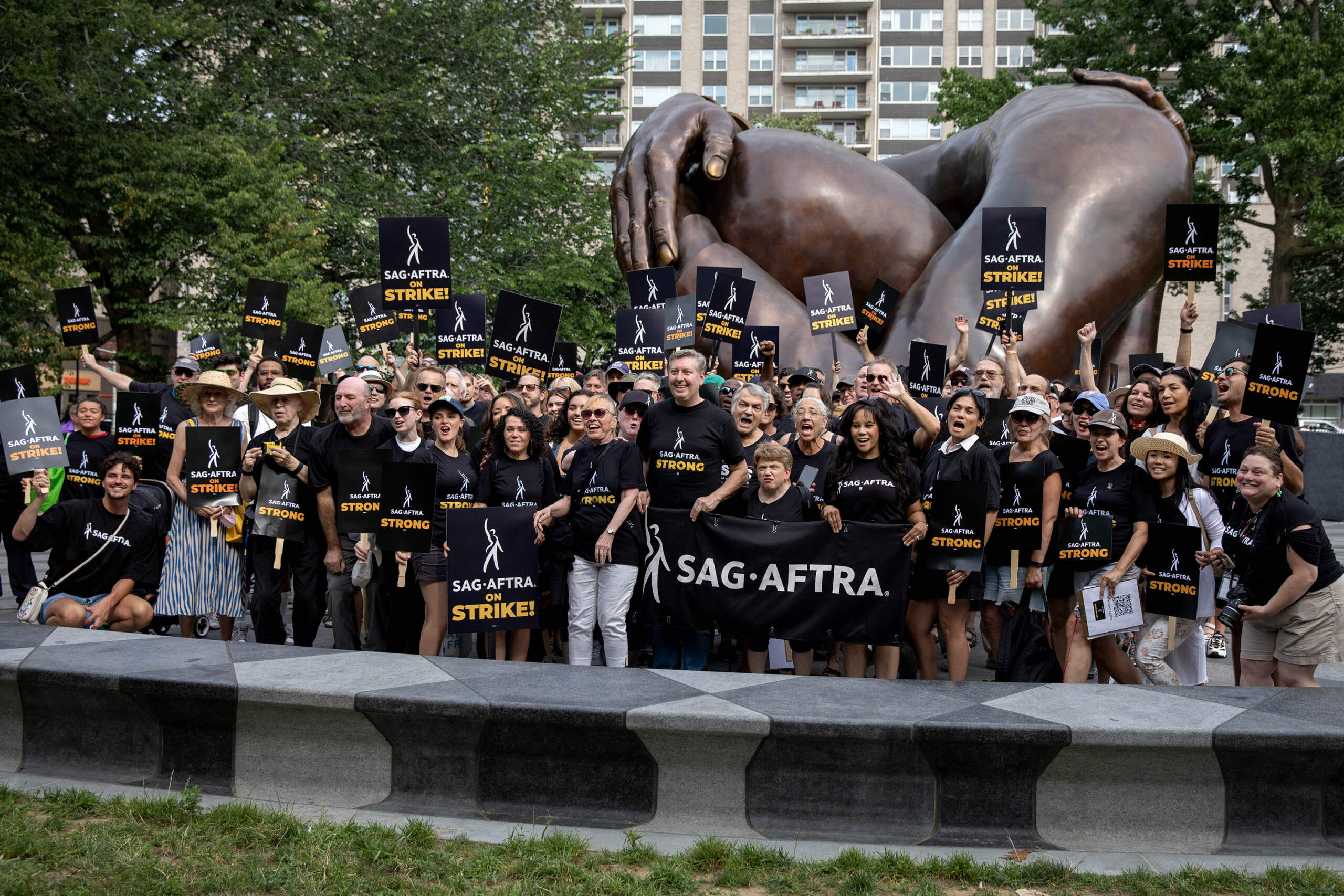 Striking SAG-AFTRA members stop for a photo by The Embrace monument on Boston Common. (Robin Lubbock/WBUR)