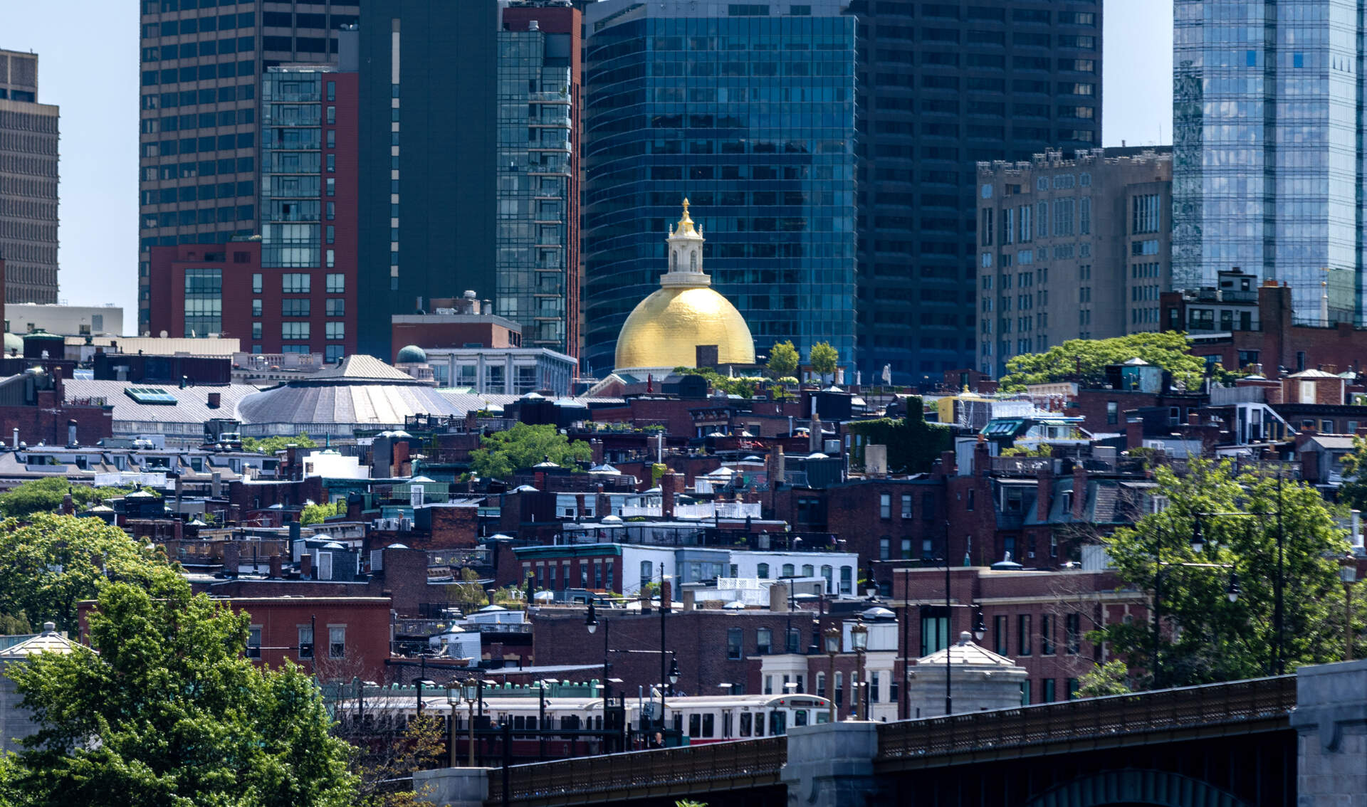 The dome of the Massachusetts State House peeks over the other buildings on Beacon Hill. (Jesse Costa/WBUR)