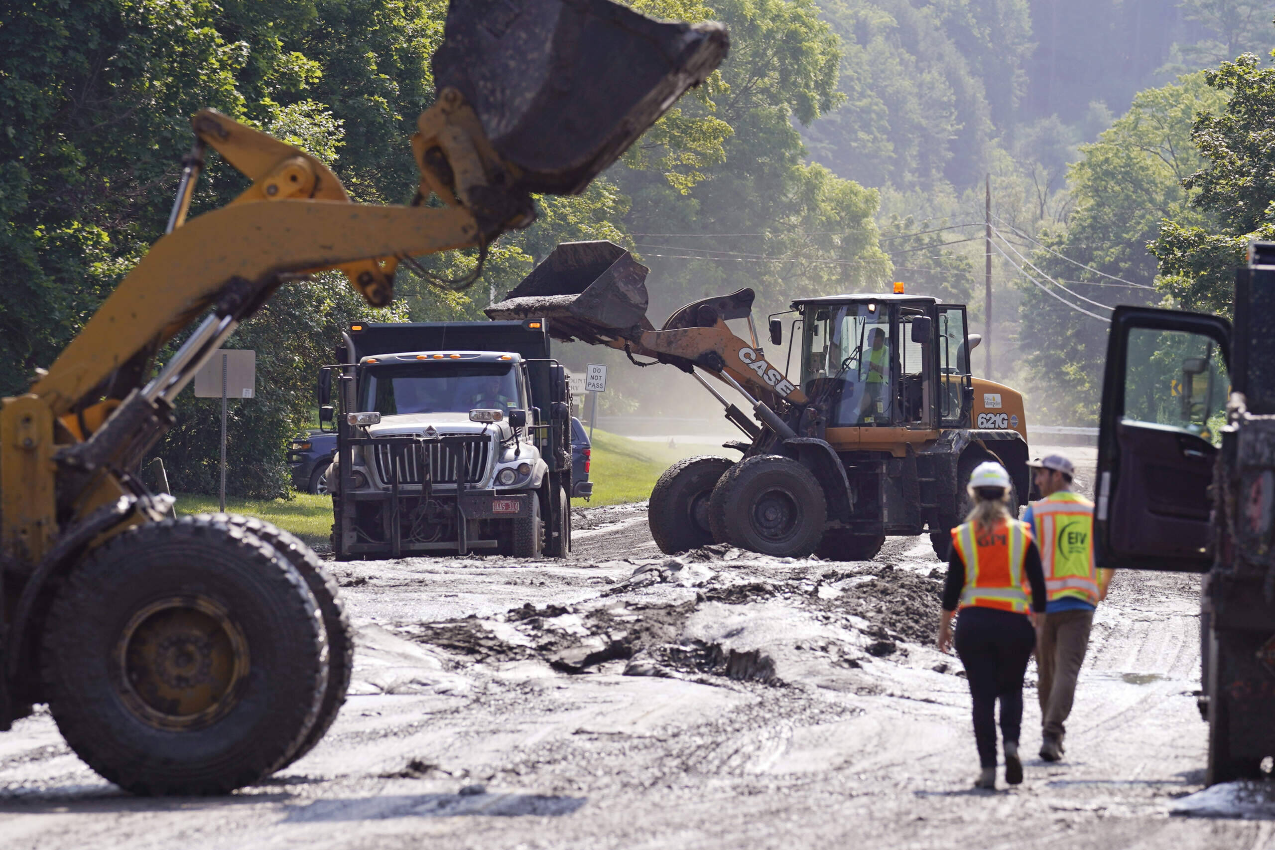 Loaders clear mud from a road leading to downtown, Wednesday, July 12, 2023, in Montpelier, Vt. (Charles Krupa/AP)