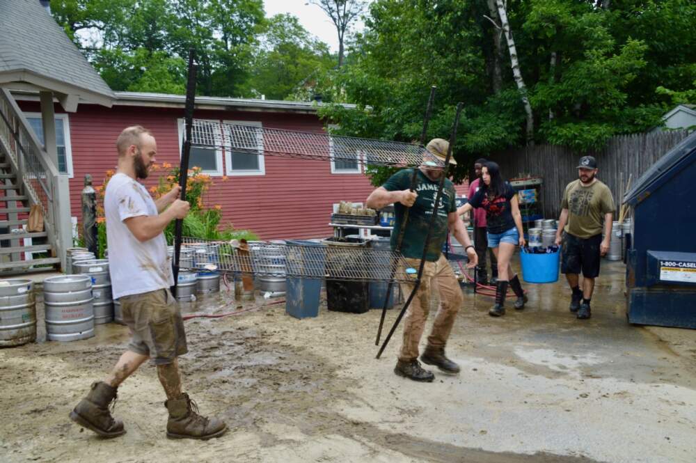 Volunteers clean out the Eight Oh Brew bar in Ludlow Wednesday. Alex DelTufo was there with her father David. They say their family owned business was hit hard by flood waters, which nearly reached the ceiling. "We're in pretty rough shape, and the damage is worse than we expected," said Alex. "But people have been showing up to help and today's been amazing, she said. "Many of these folks are our patrons and we couldnd't be more grateful." (Nina Kek/Vermont Public)