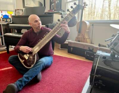 Eric Shimelonis playing the sitar. (Rebecca Sheir for WBUR)