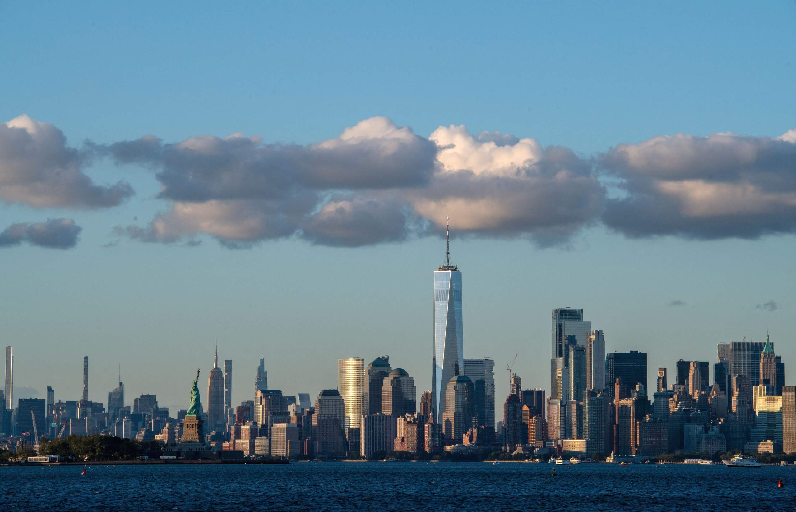 Clouds sit above the Manhattan skyline and Statue of Liberty in New York City. (Photo by Angela Weiss/AFP via Getty Images)