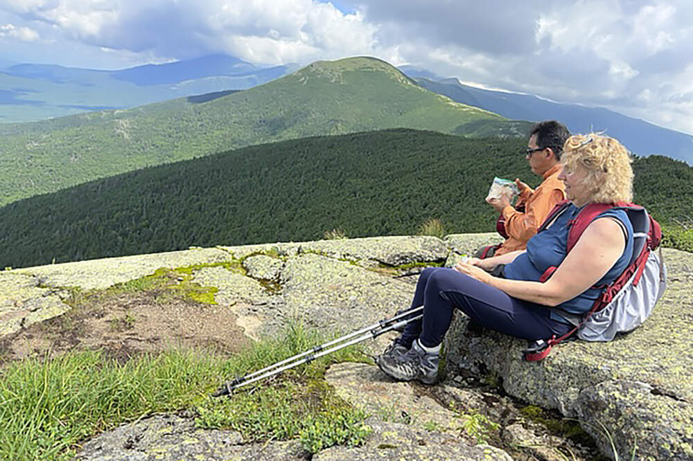 Olivera Bogunovic, front right, and Jorge Sotelo, behind, rest near the summit of New Hampshire's Mount Pierce, in Coos County, N.H., Saturday, July 8, 2023. (Holly Ramer/AP)