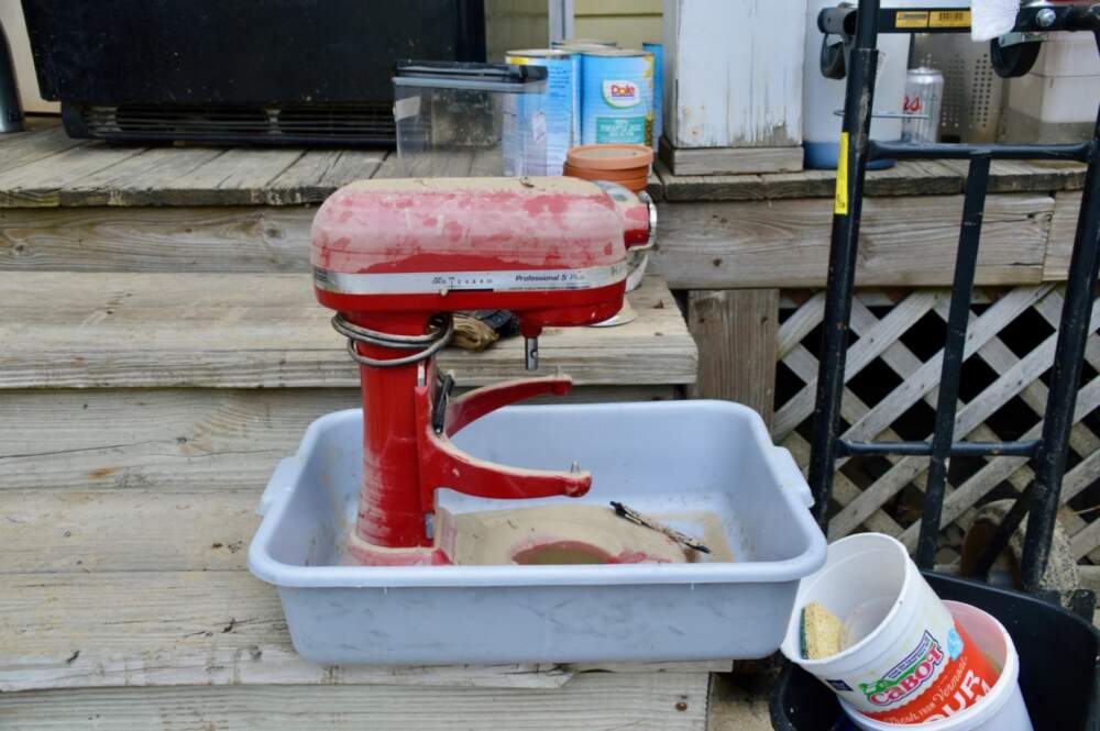 The Homestyle Hostel in Ludlow sits right up against the Black River, which today is a muddy brown. A red KitchenAid mixer looks sadly out of place covered with mud on the steps. (Nina Keck/Vermont Public)