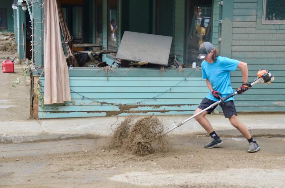 Bryson Lawrence helps with cleanup in Ludlow on Wednesday. (Nina Keck/Vermont Public)