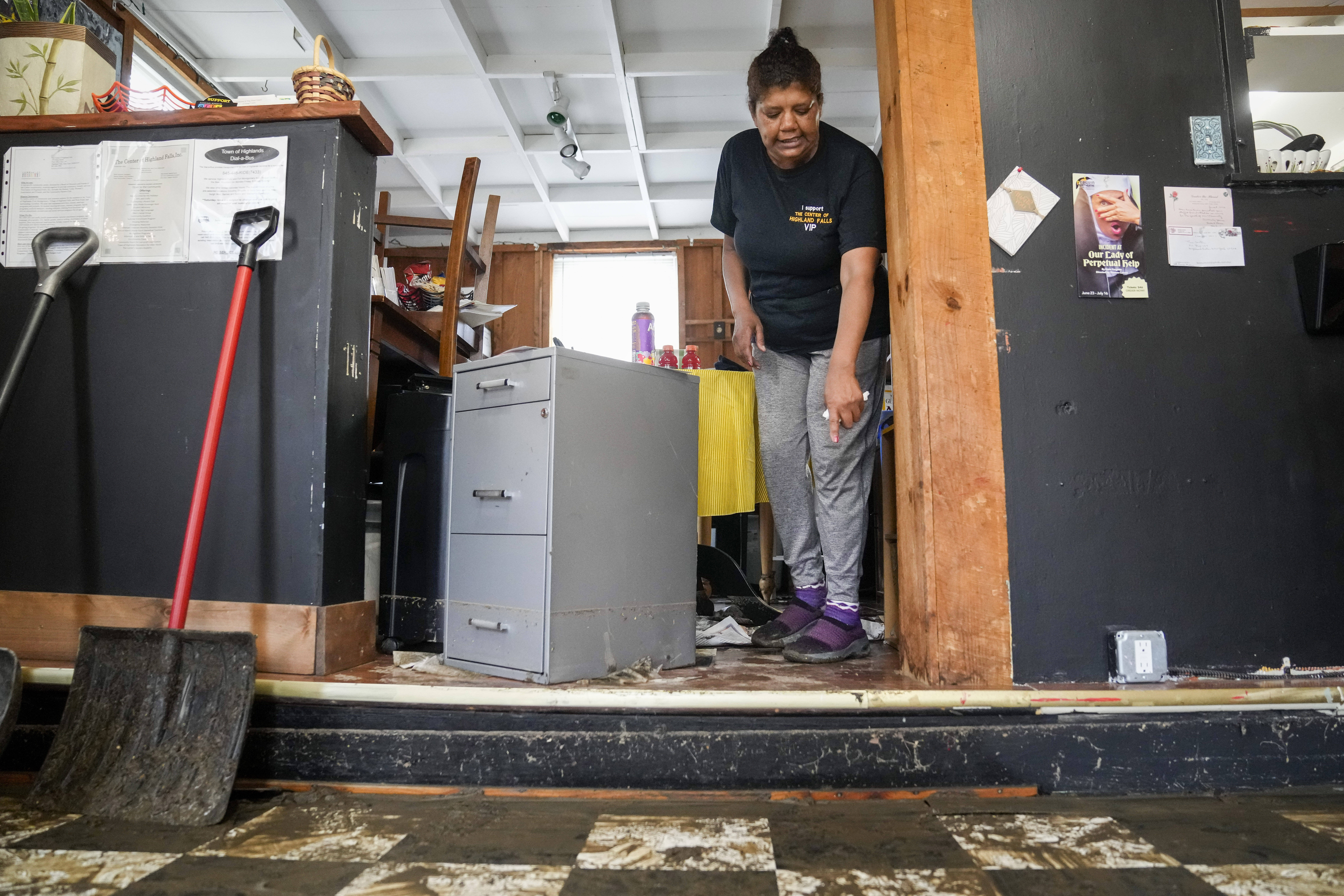 Kathy Eason, a worker at the Center for Highland Falls, points to the waterline where she had been trapped by floodwaters the previous day inside the organizations storefront, July 10, 2023, in Highland Falls, N.Y. (John Minchillo/AP)