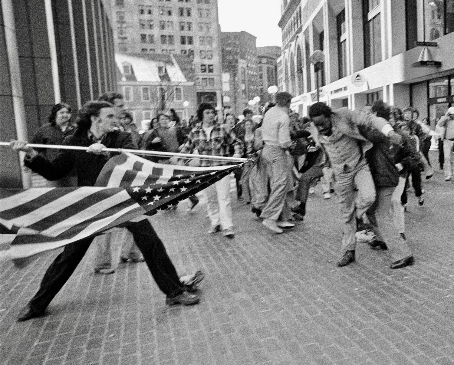 In this photograph titled &quot;The Soiling of Old Glory,&quot; Joseph Rakes assaults lawyer and civil rights activist Ted Landsmark with a flagpole bearing the American flag. (Stanley Forman)