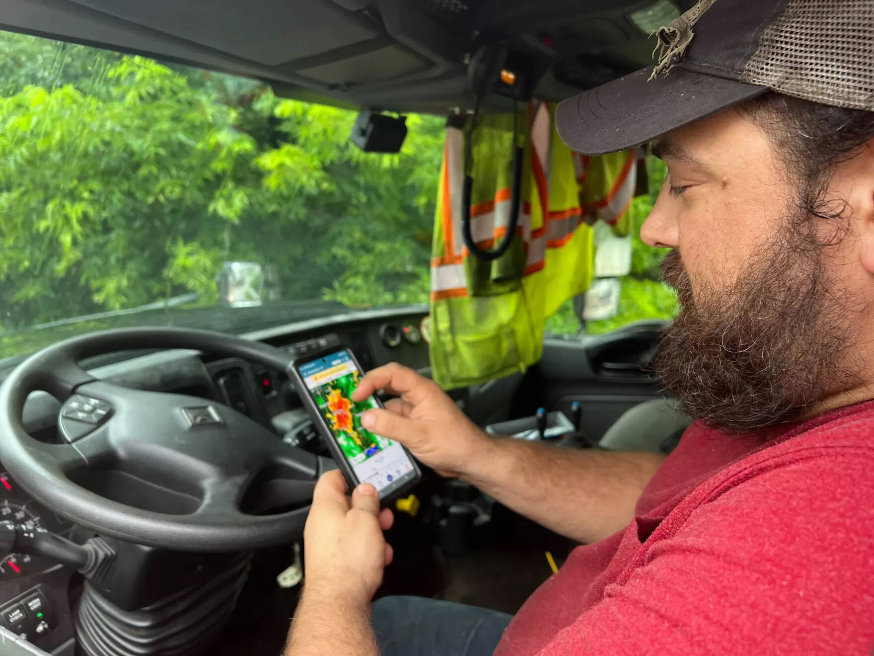 Brian Pelchuck of the Vermont Agency of Transportation's Middlesex garage monitors rising waters on Dascomb Rowe Field as they inch towards Route 2 in Waterbury on Monday afternoon. (Brian Stevenson/Vermont Public)