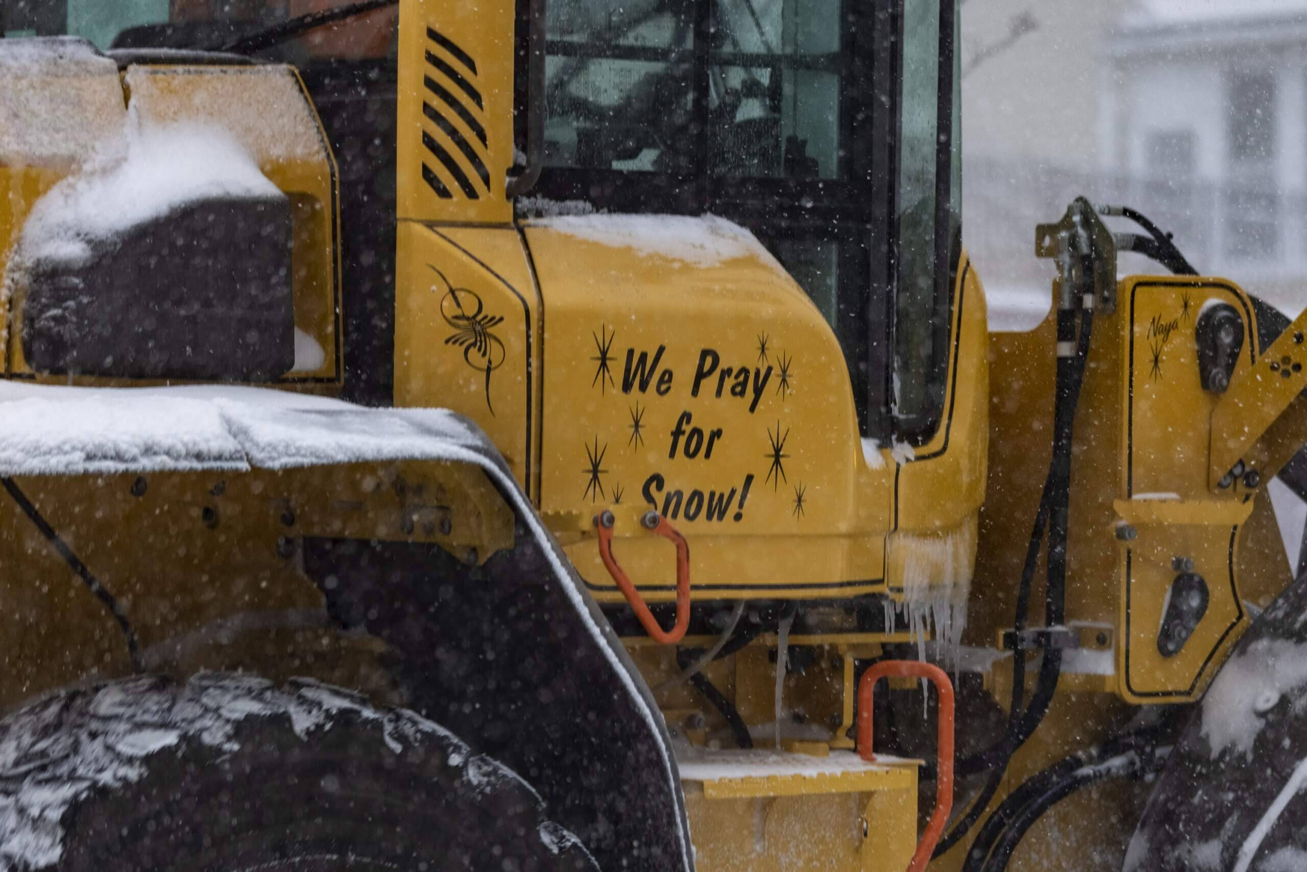 The words ‘We Pray for Snow’ are written on the side of a plow truck in Somerville. (Jesse Costa/WBUR)