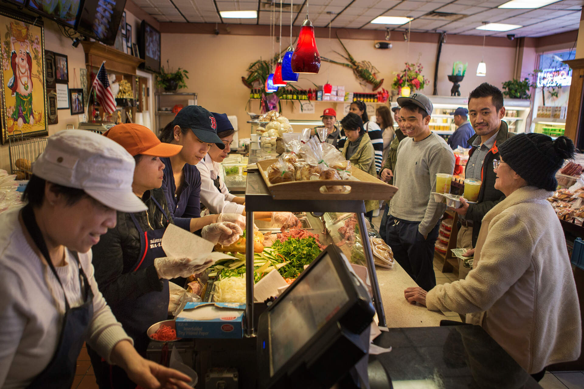 The counter at Ba Le remains busy during lunchtime. The owner says the restaurant makes at least 400 banh mi sandwiches a day. (Jesse Costa/WBUR)