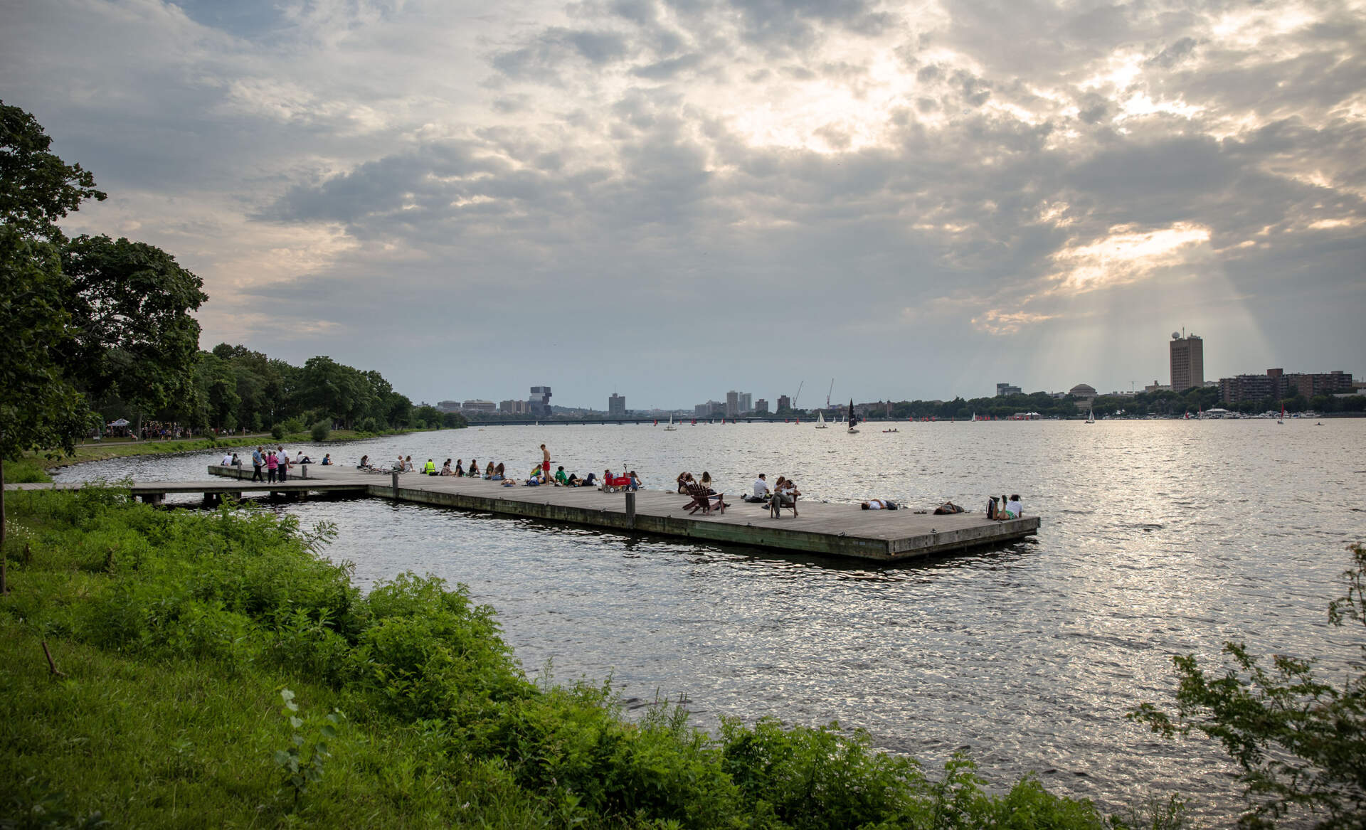 Back Bay residents relax on a dock by the Esplanade on a summer evening. (Robin Lubbock/WBUR)