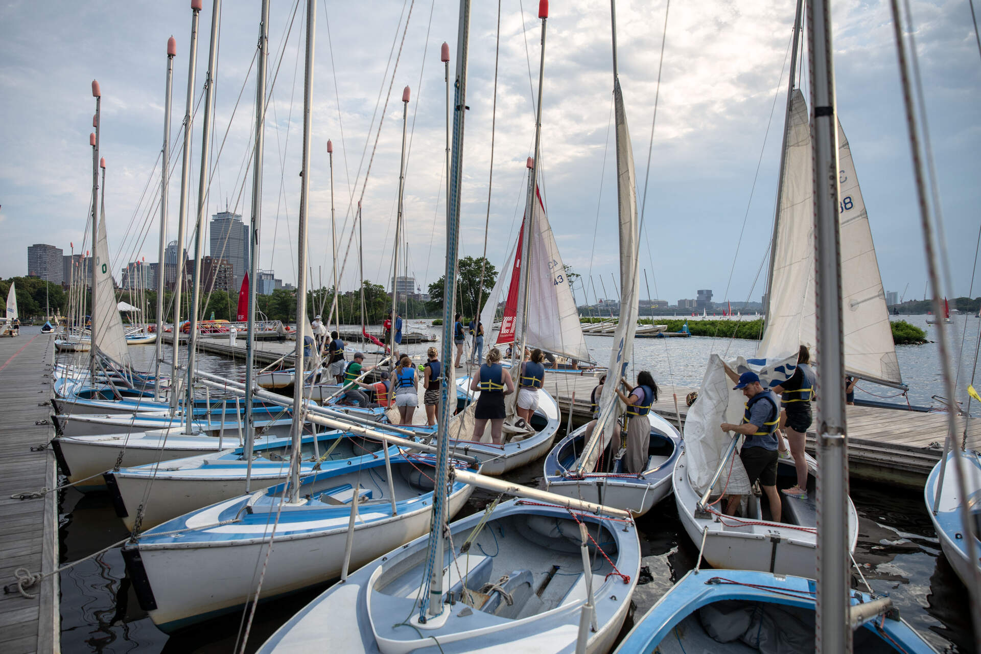 Crews rig sailboats at Community Sailing on the Charles River. (Robin Lubbock/WBUR)