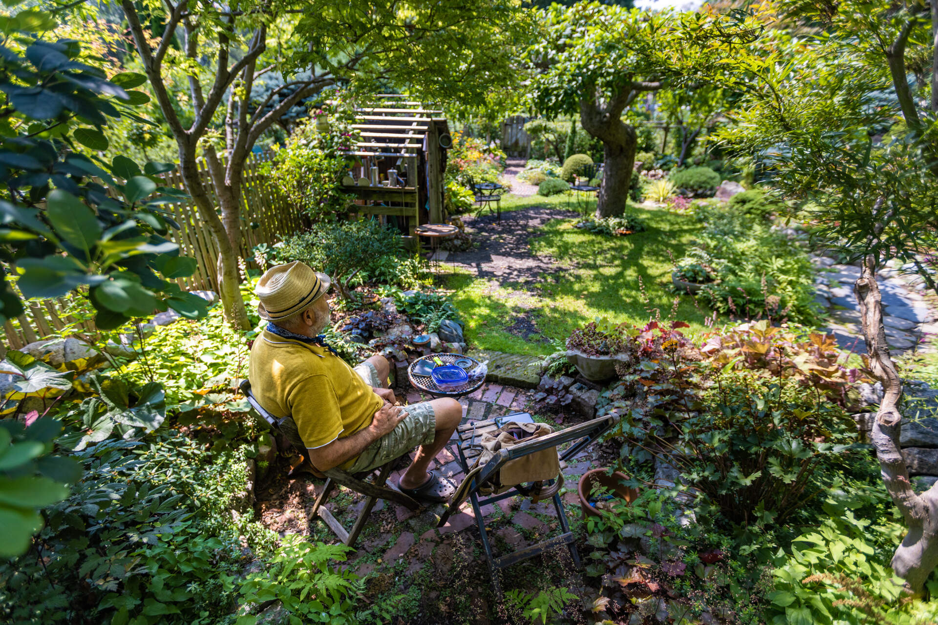 Richard Malkasian sits and relaxes in his garden plot, 36 years in the making, at the Fenway Victory Gardens. (Jesse Costa/WBUR)