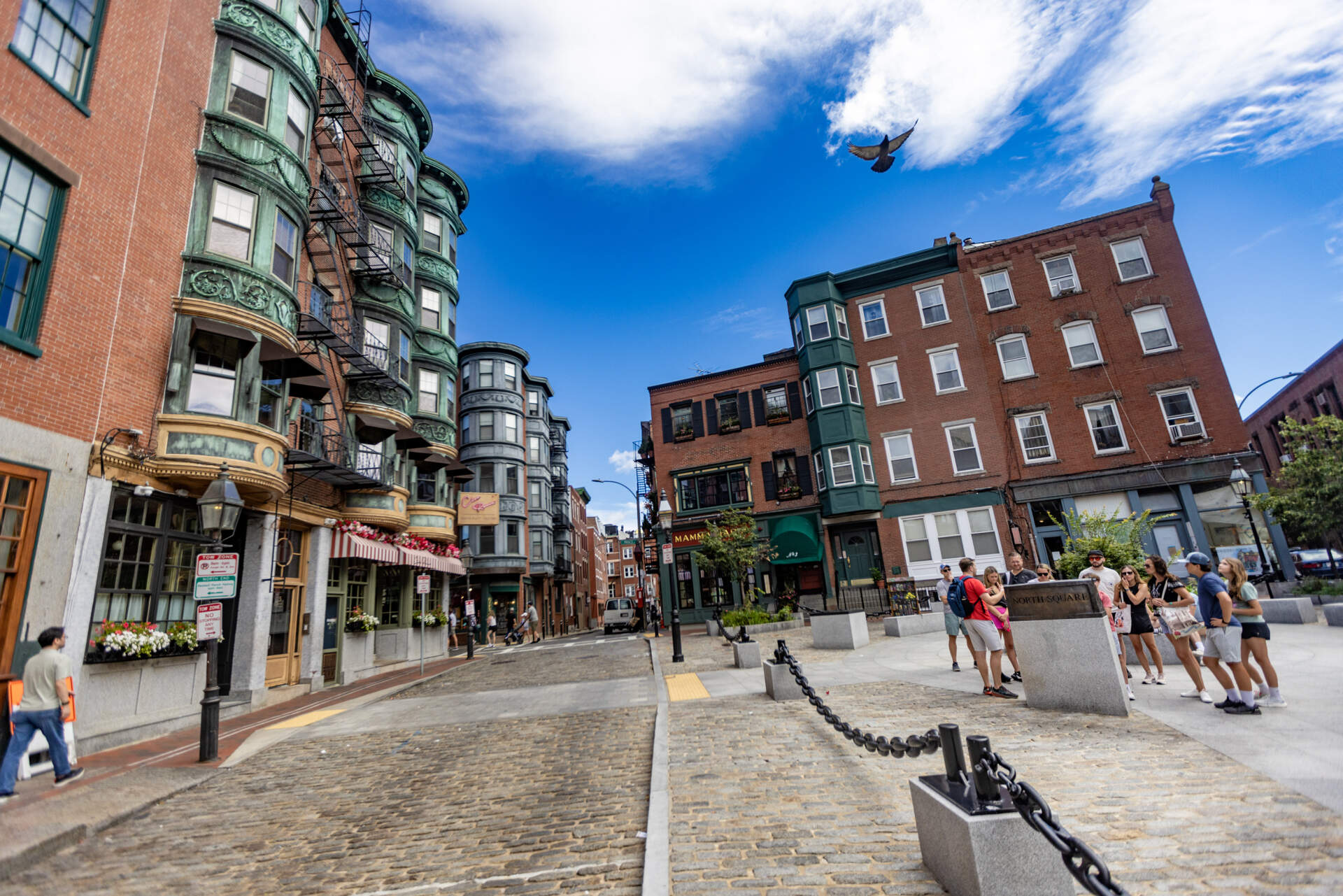 A tour group learns about the sites around North Square Park in the North End. (Jesse Costa/WBUR)