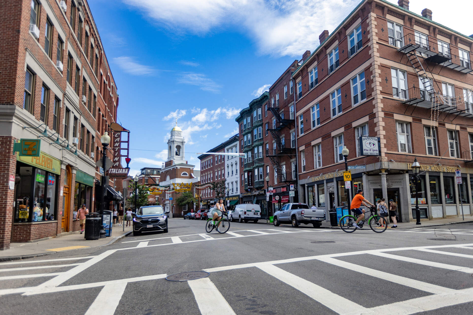 Bicyclists turn off of Hanover Street onto Tony DeMarco Way in the North End. (Jesse Costa/WBUR)