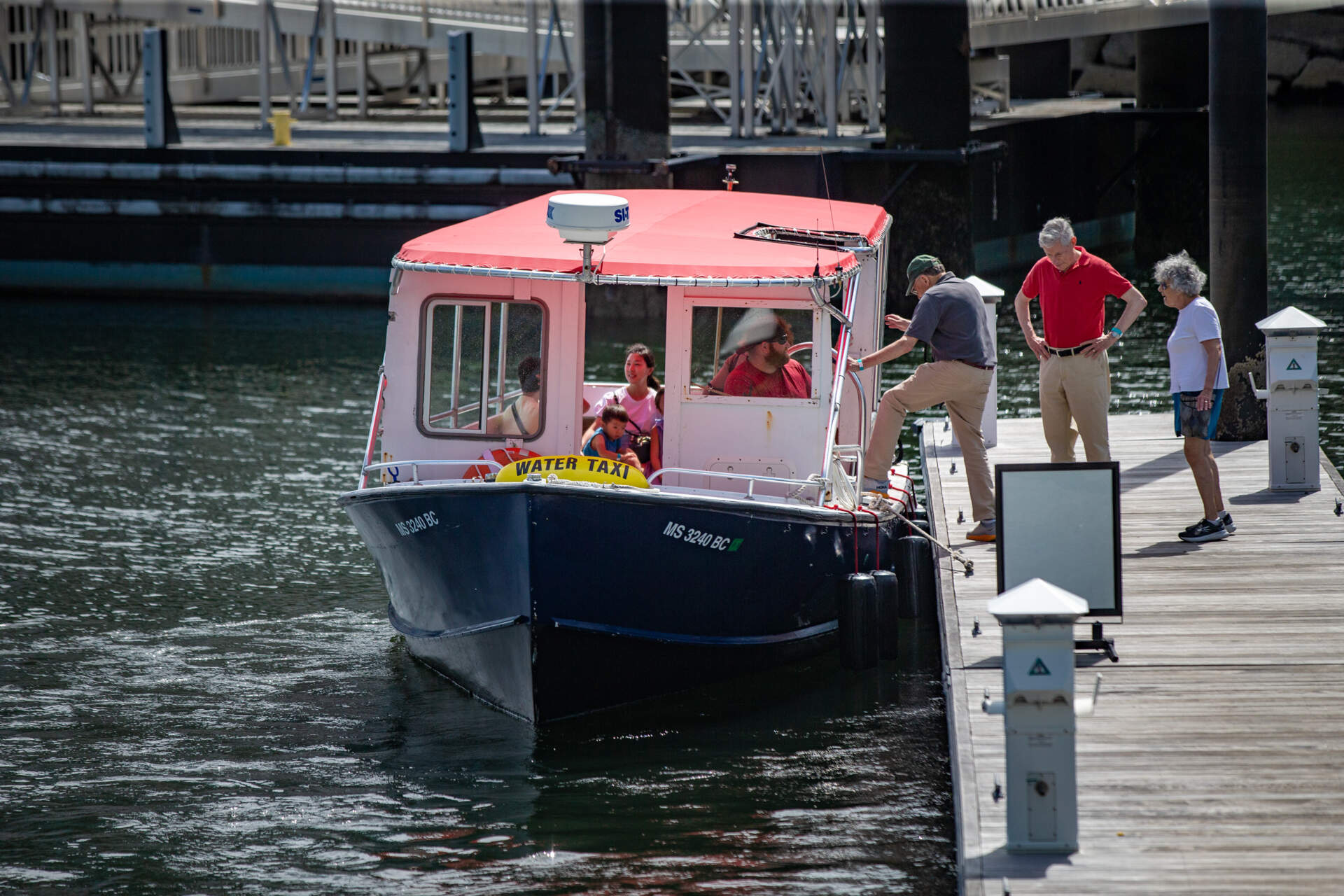 People climb aboard a water taxi bound for East Boston at Fan Pier in the Seaport. (Jesse Costa/WBUR)