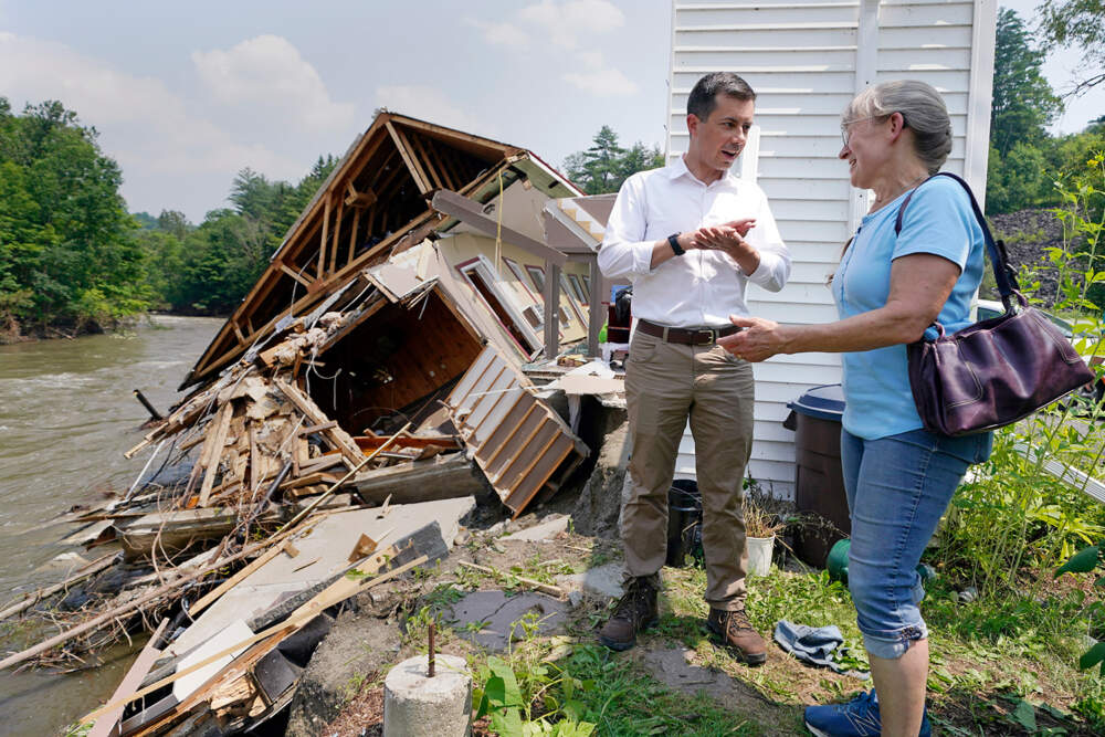 Transportation Secretary Pete Buttigieg listens to Freda Hollyer, right, owner of the Inn by the River, describe flood waters, which destroyed her family's hotel, along the banks of the Lamoille River, Monday, July 17, 2023, in Hardwick, Vt. Last week's storms dumped up to two months' worth of rain in a couple of days in parts of Vermont and New York. (AP Photo/Charles Krupa)