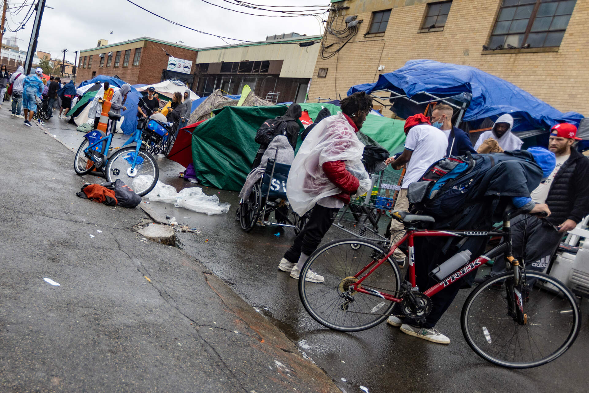 People congregate around the tents on Atkinson Street in the area known as "Mass. and Cass," Aug. 25, 2023. (Jesse Costa/WBUR)