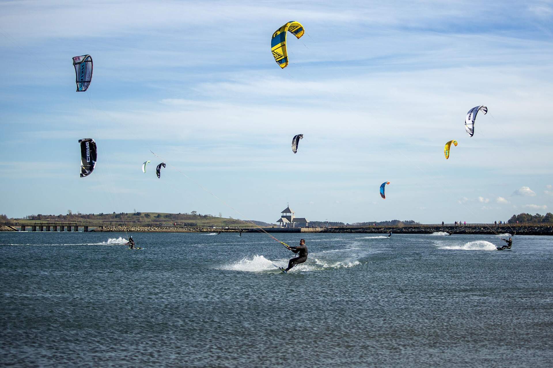 Kite-surfers enjoy a sunny, windy afternoon at Pleasure Bay, by Castle Island in South Boston. (Robin Lubbock/WBUR)