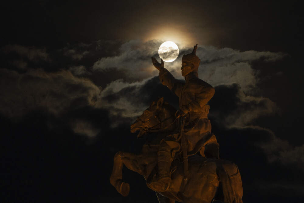The supermoon rises near the equestrian statue of Damdin Sukhbaatar on Sukhbaatar Square in Ulaanbaatar, Mongolia, on Wednesday, Aug. 30, 2023. (Ng Han Guan/AP)
