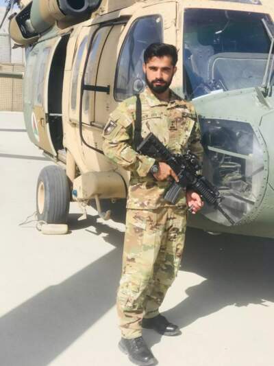 Azimullah Mohammadi posing with a Black Hawk helicopter in Afghanistan. Mohammadi piloted a different helicopter, the Russian-built Mi-17, for an elite unit of the Afghan armed forces. (Courtesy of Azimullah Mohammadi)