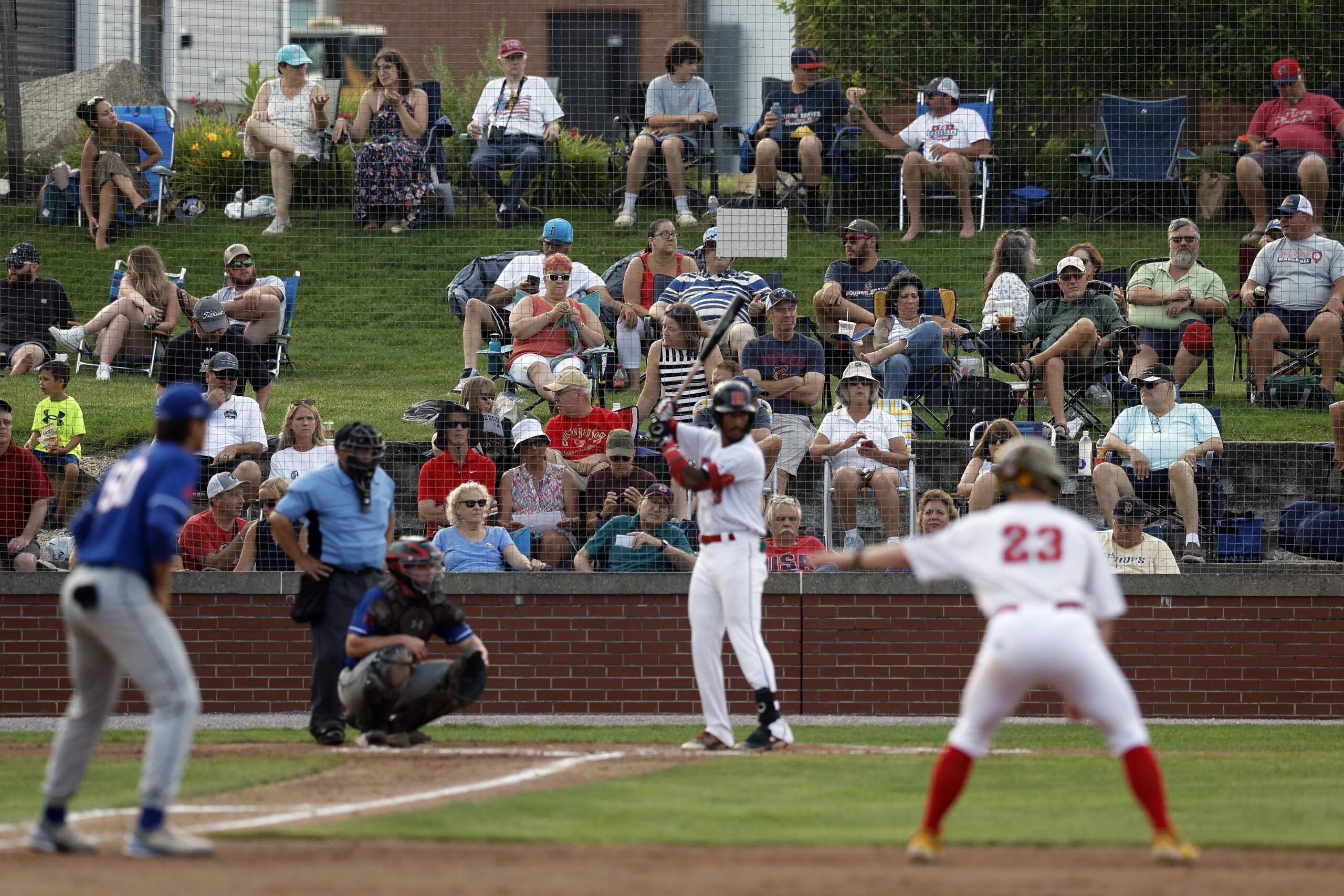 Fans watch the Cape Cod League baseball game between the Chatham Anglers and the Bourne Braves, Wednesday, July 12, 2023, in Bourne, Mass. For 100 years, the Cape Cod League has given top college players the opportunity to hone their skills and show off for scouts while facing other top talent from around the country. (Michael Dwyer/AP)