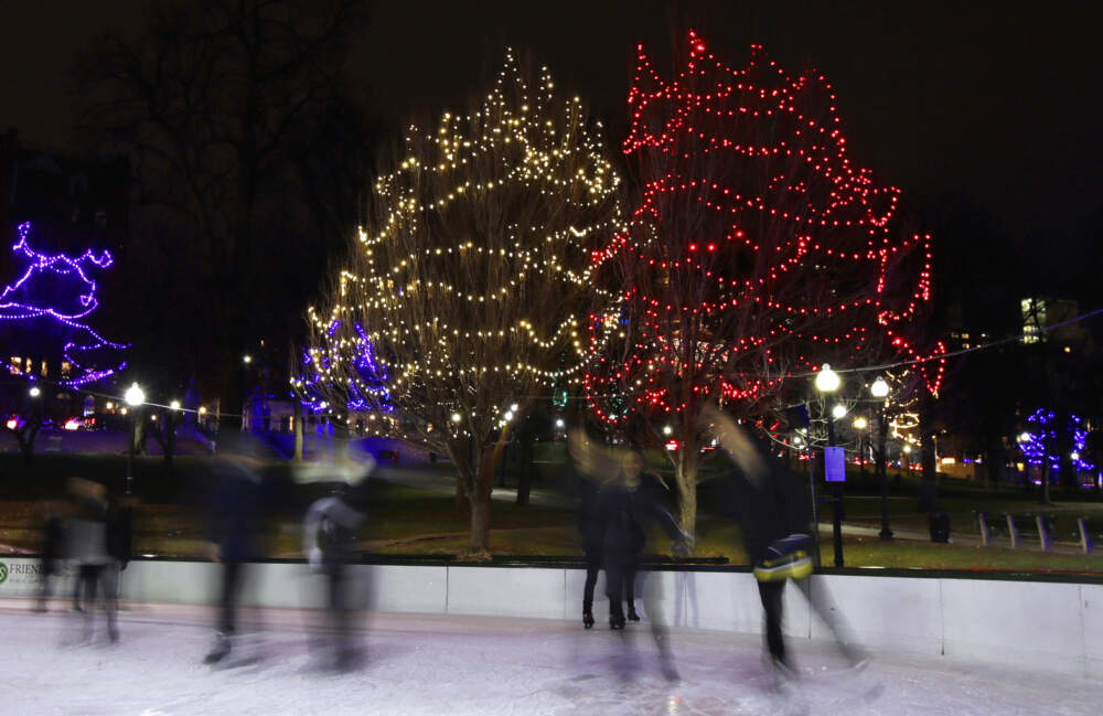 Skaters blur as they skate past Christmas lights on Boston Common while skating on the Frog Pond. (Charles Krupa/AP)