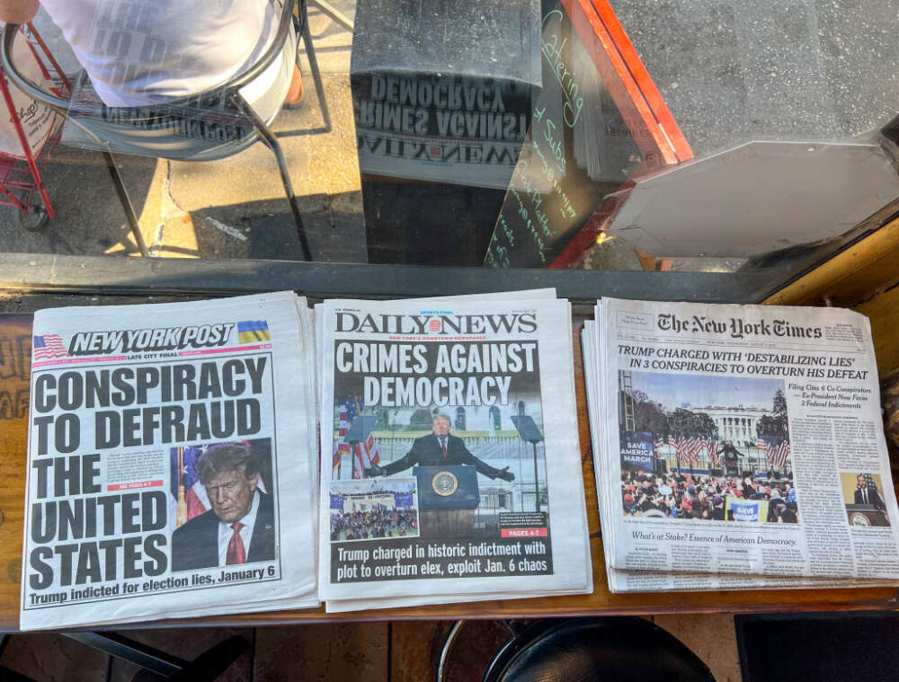 Headlines on three daily newspapers report the indictment of former President Donald Trump August 2, 2023 in New York City. Trump was indicted on four felony counts for his alleged efforts to overturn the 2020 election. (Robert Nickelsberg/Getty Images)