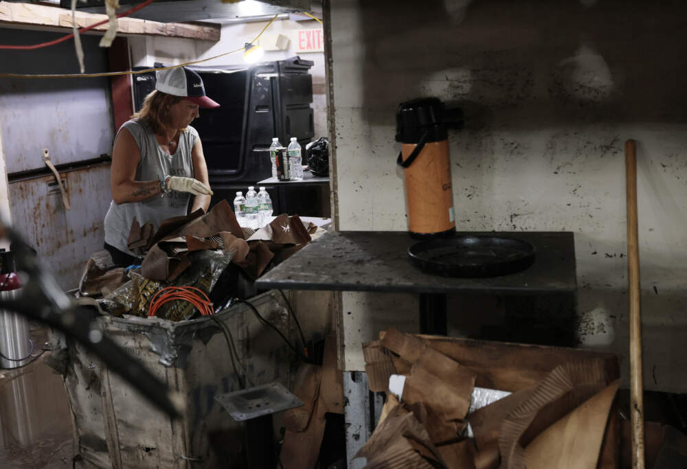 Carol Hedges helps throw away items in the basement of Jaime's Restaurant as she and others work to clean up from the damage caused by the flooding. (Photo by Jessica Rinaldi/The Boston Globe via Getty Images)