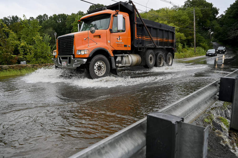A truck drives through water on Route 133 along Lake Cochichewick in after flooding. (Photo by Vincent Alban/The Boston Globe via Getty Images)