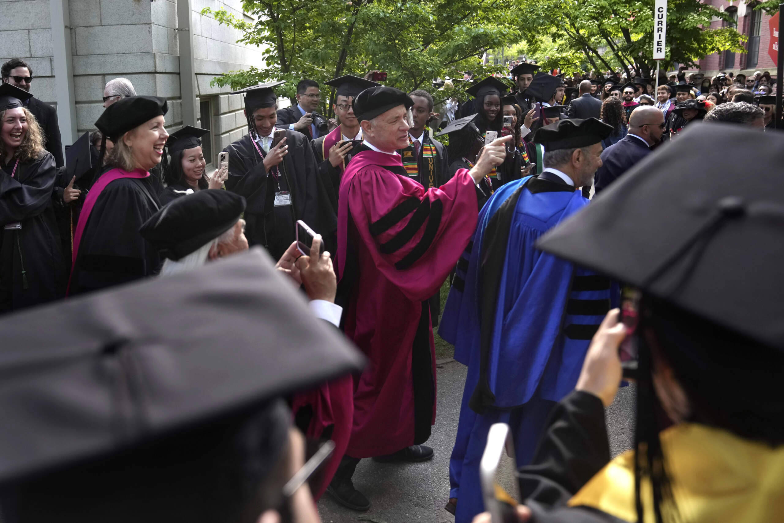 Actor and 2023 Harvard commencement speaker Tom Hanks greets students as he walks in a procession though Harvard Yard. (Steven Senne/AP)