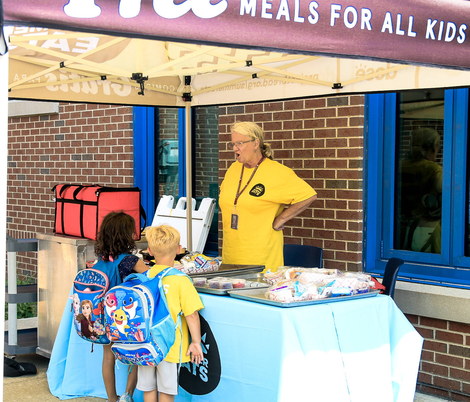 Dedham Schools Food Service Manager Jean Clark hands out lunch during Summer Eats. (Emily Piper-Vallillo/WBUR)