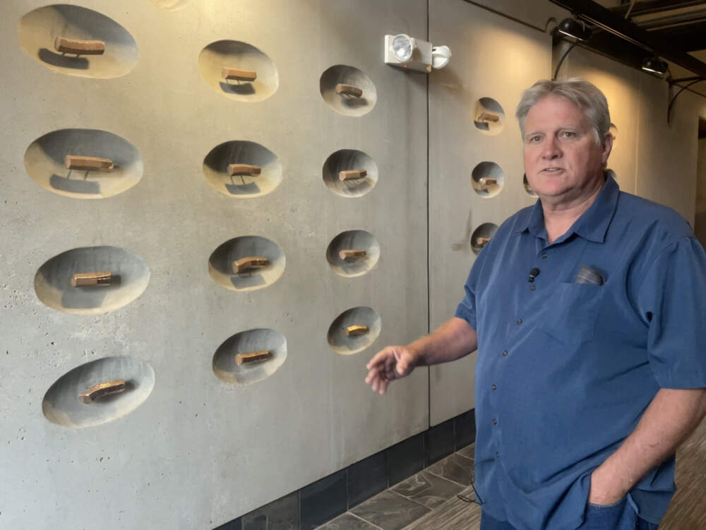 Richard Pitchford, the Metro Biosolids Center’s superintendent, stands beside one of his favorite pieces inside the main administrative building. June 2023. (Scott Rodd / KPBS)