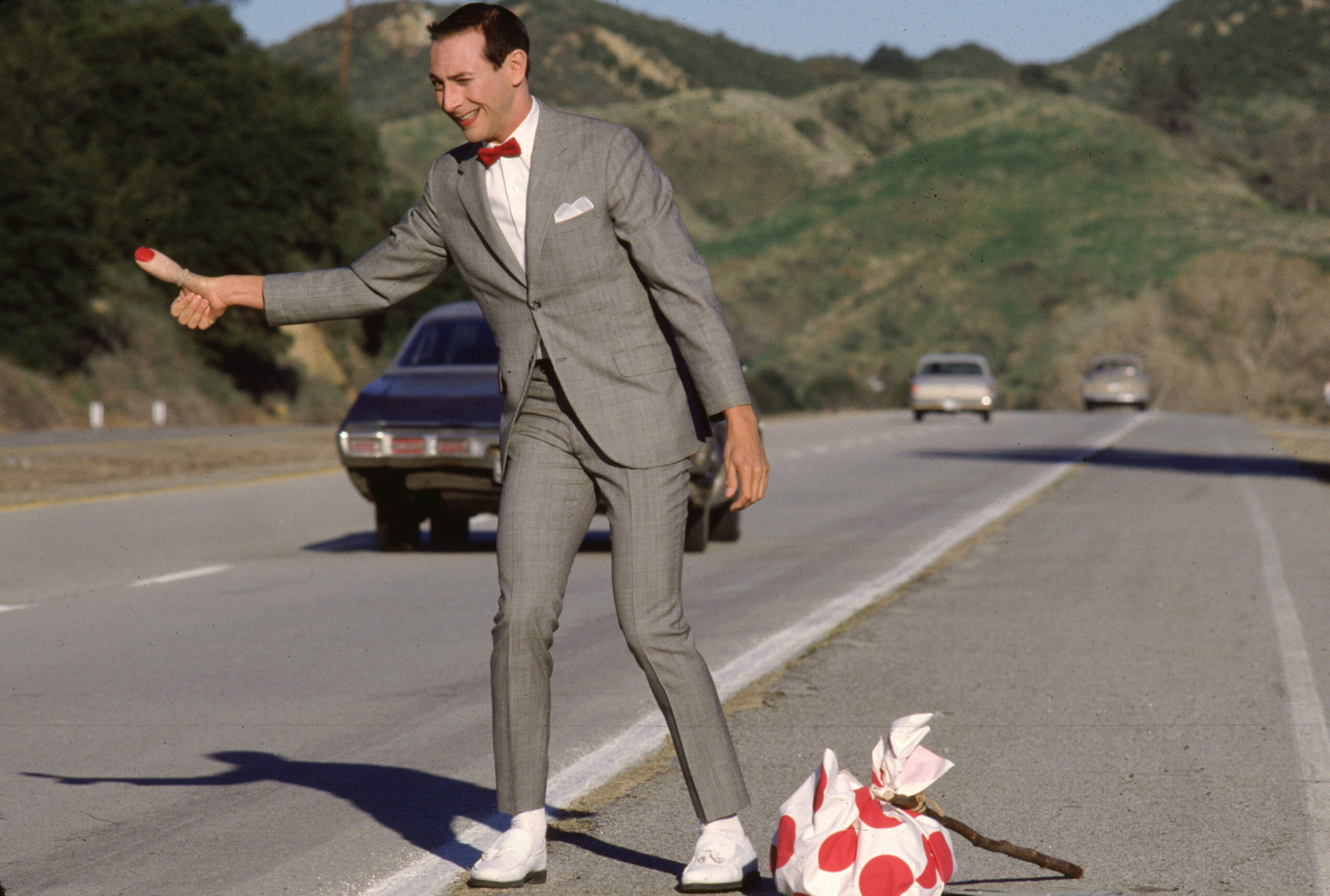 Paul Reubens hitchhikes as Pee-wee Herman in "Pee-wee's Big Adventure." (Courtesy Warner Bros.)