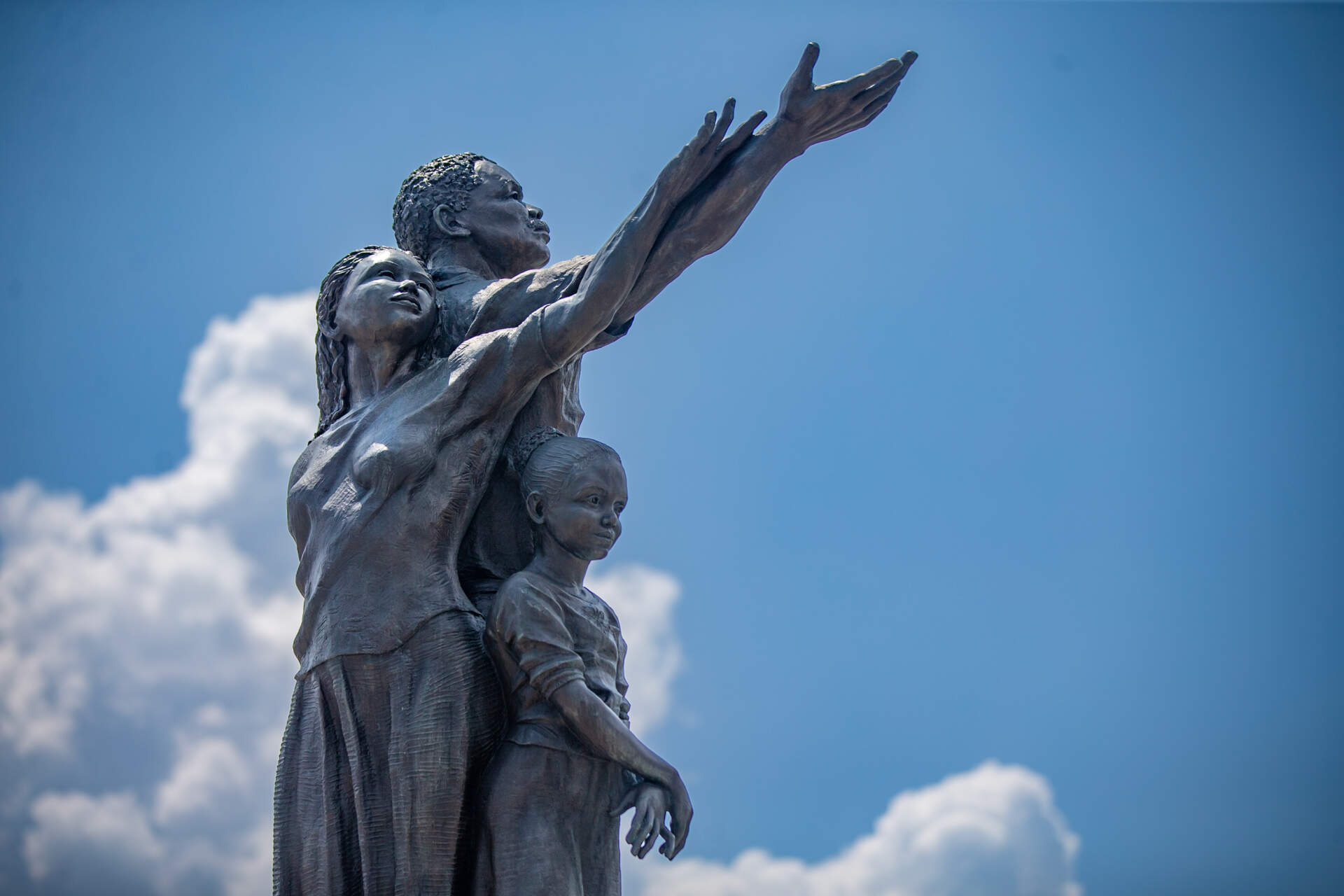 The 19-foot bronze sculpture by former Mattapan resident Fern Cunningham and Karen Eutemey stands at the gateway to Mattapan Square on Blue Hill Avenue. (Jesse Costa/WBUR)