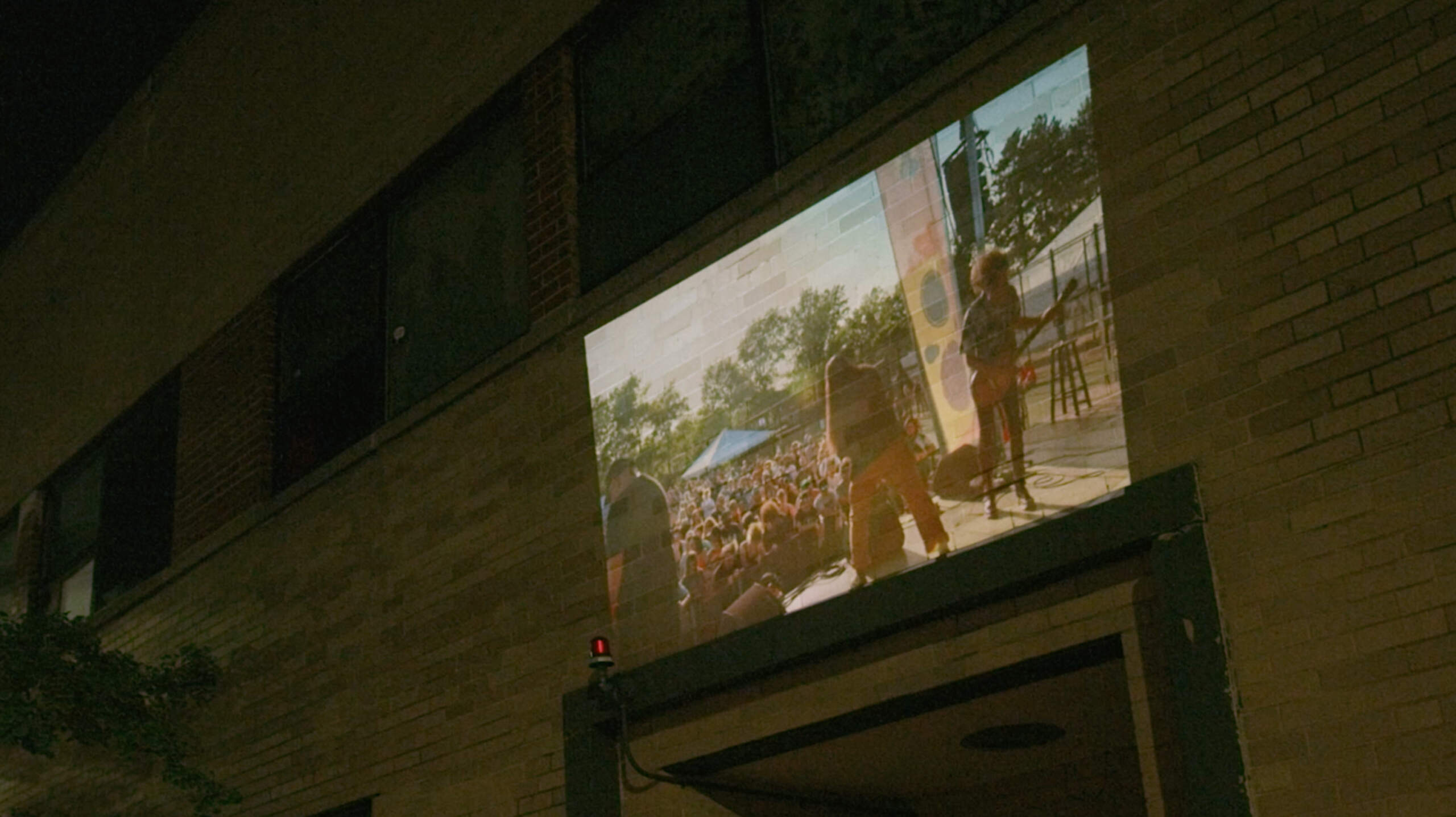 A still from the "Fool's Gold" music video where footage from Boston Calling is being projected on the former Sound Museum building. (Courtesy Ben Eames)