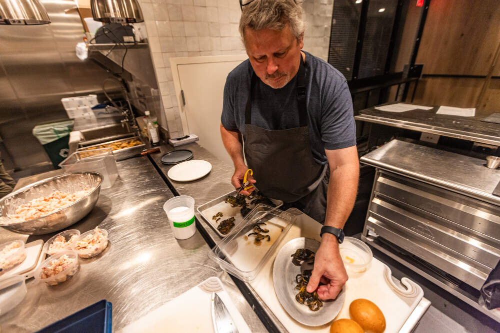 Chef Jeremy Sewall of Row 34 cleans a green crab by removing the claws and gills as he prepares a green crab slider at the restaurant. (Jesse Costa/WBUR)